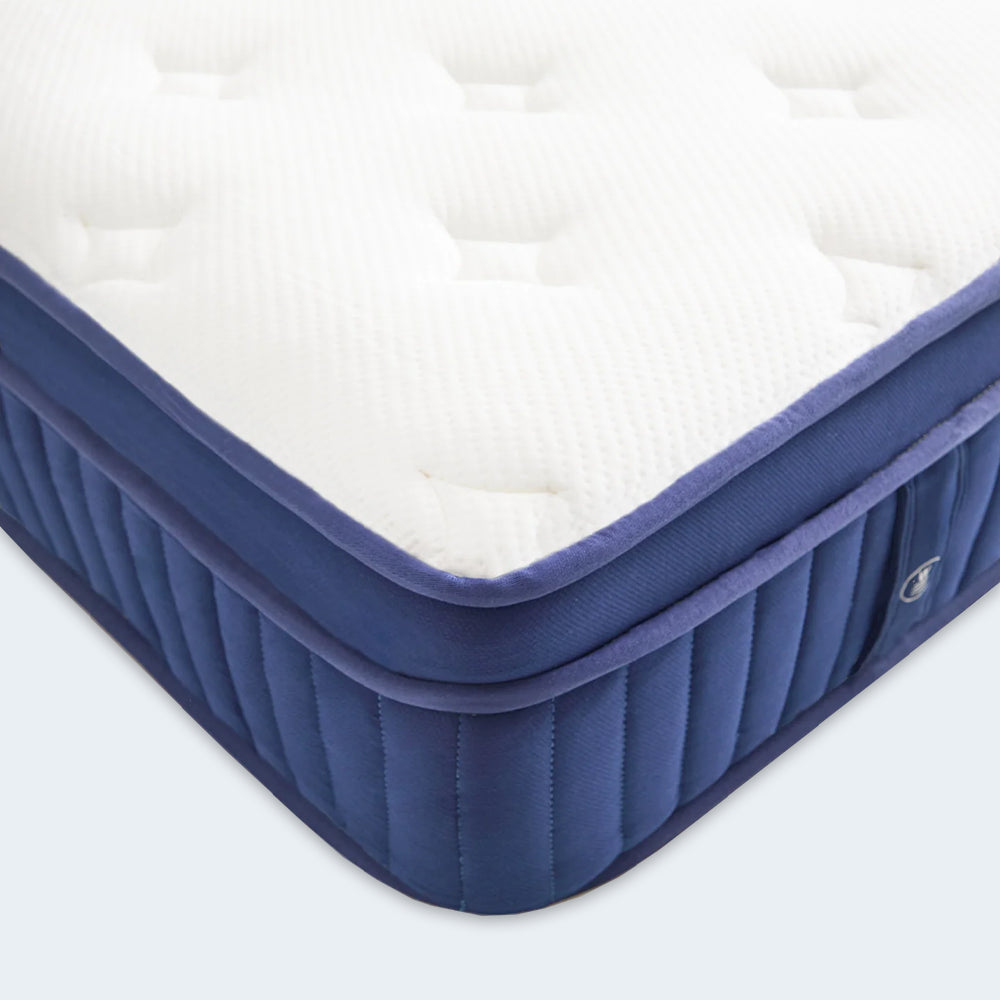 Hand pressing into the white quilted cover of the Weekender 13-inch plush mattress to show responsive pressure relief and comfort.
