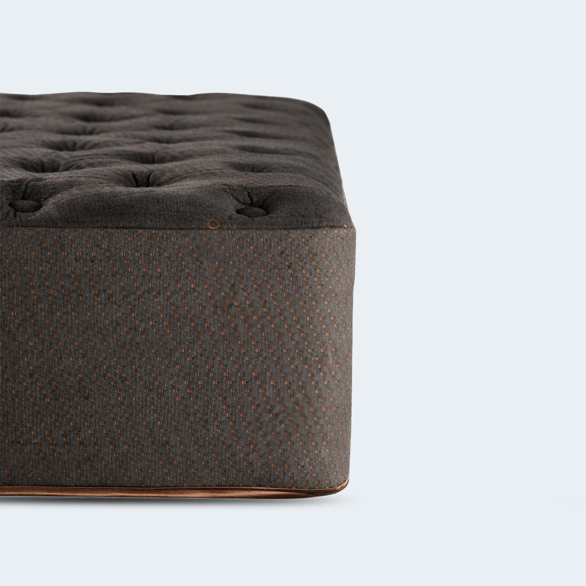 Detailed shot of the Tommie Copper Core Znergy mattress corner highlighting the copper-infused fabric and tufted plush top.
