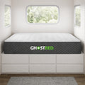 GhostBed RV 10-inch hybrid mattress fitted on a custom platform bed inside a modern camper van or tiny home.
