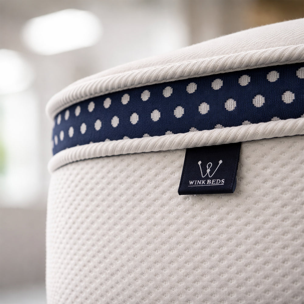 Detailed view of the handcrafted WinkBeds branded tag on the corner of a premium 13.5-inch luxury firm hybrid mattress.