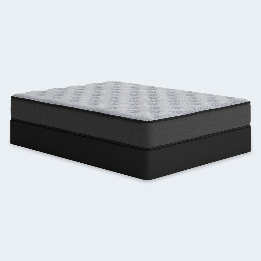 Perspective studio shot of the Comfort Plus 10-inch mattress featuring a grey quilted top and charcoal side panels with a wavy stitch pattern.
