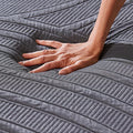 Hand pressing into MLILY memory foam to demonstrate the responsive pressure relief of the PowerCool mattress.
