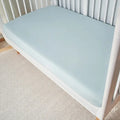 Light blue Hyper-Wool performance crib sheet on a white crib for a temperature-neutral nursery.
