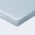 Detailed shot of a light blue moisture-wicking Hyper-Linen crib sheet corner for temperature regulation.
