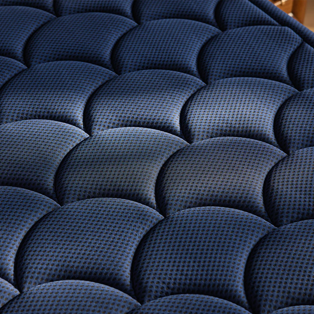 Detailed close-up of the DreamCloud Ultra signature navy blue scalloped quilted cover designed for maximum breathability and plush comfort.
