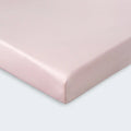 Corner of a pink Dri-Tec performance crib sheet showing the breathable knit and secure fit.
