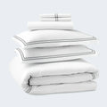 Folded SleepTone white hotel luxury duvet set with elegant silver double-stripe embroidery.
