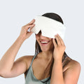 Woman holding a matching pillow while wearing the blue BEDGEAR Hyper-Silk Performance Sleep Mask.
