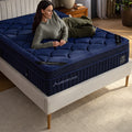 High-angle bedroom shot of a woman lying on a DreamCloud Ultra mattress, highlighting the adaptive pressure relief of the scalloped quilted top.
