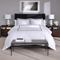 Symmetrical view of white SleepTone Hotel Luxury sheets with grey double-stripe embroidered borders.
