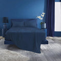 Deep navy blue Ver-Tex cooling sheet set on a modern bed setup in a bold, contemporary room.
