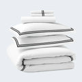 Premium SleepTone Hotel Luxury white bedding stack featuring deep navy double-stripe embroidery.
