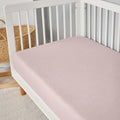 Folded pink BEDGEAR Hyper-Linen performance crib sheet, moisture-wicking for a comfortable nursery.
