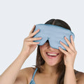 Woman sleeping peacefully on a blue pillow wearing the blue BEDGEAR Hyper-Silk contoured sleep mask.

