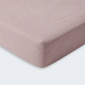 Folded pink BEDGEAR Hyper-Linen performance crib sheet, moisture-wicking for a comfortable nursery.
