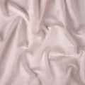 Soft pink Hyper-Linen crib sheet on a standard mattress for a temperature-regulating baby sleep space.
