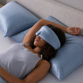 Woman sleeping peacefully on a blue pillow wearing the blue BEDGEAR Hyper-Silk contoured sleep mask.
